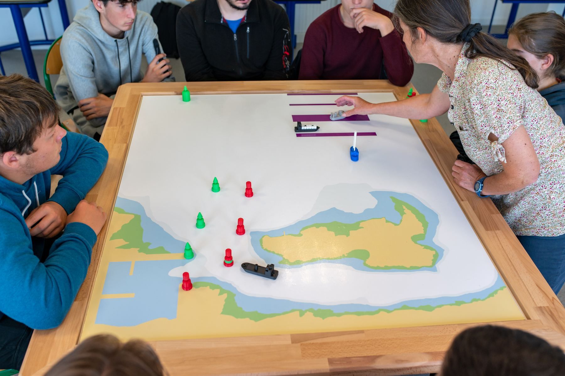 Students and their instructor around the Nauticademy board